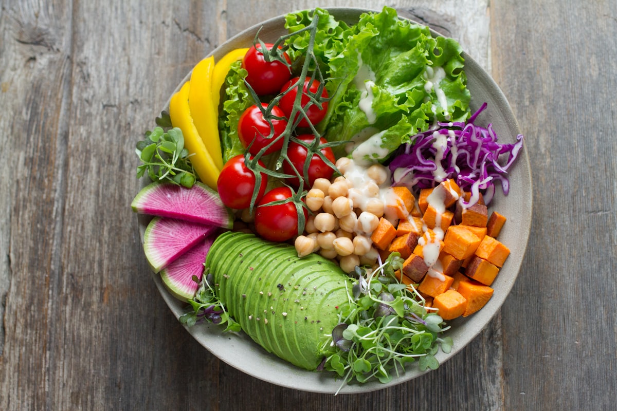 A bowl of leafy greens with vegetables.